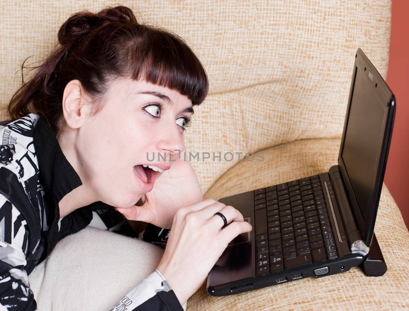 a real young woman typing in the keypad of a laptop