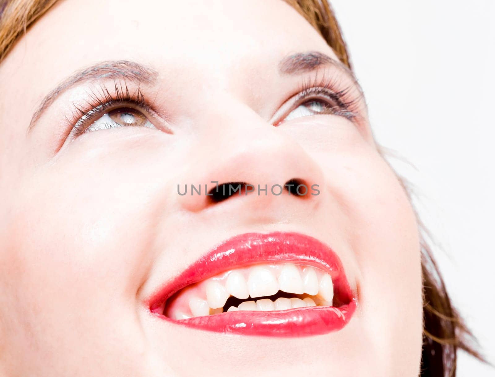 joyful simle of a beautiful young girl with sexy red lips looking upwards
