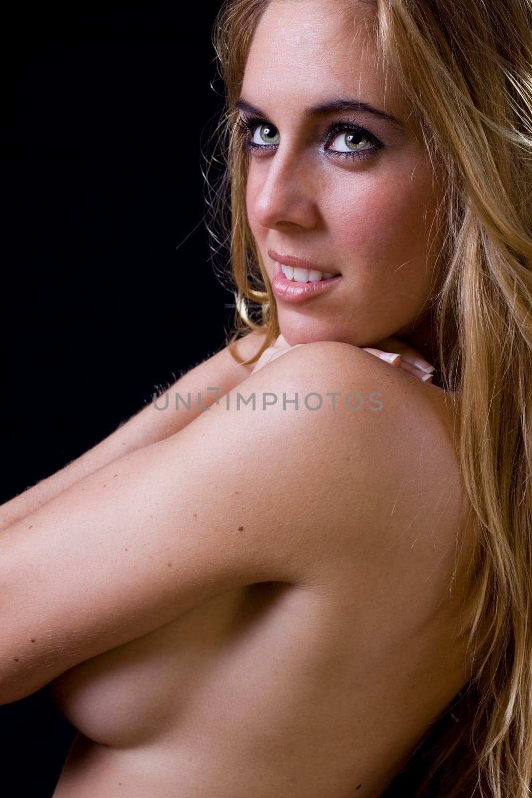 sensual and elegant image of a gorgeous young blond girl covering her breast with the arms