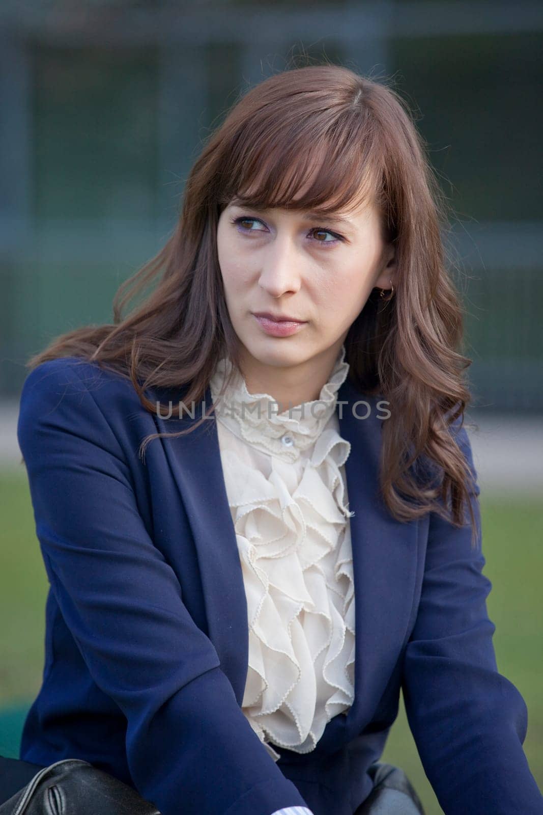 portrait of sad woman in elegant jacket sitting outdoor