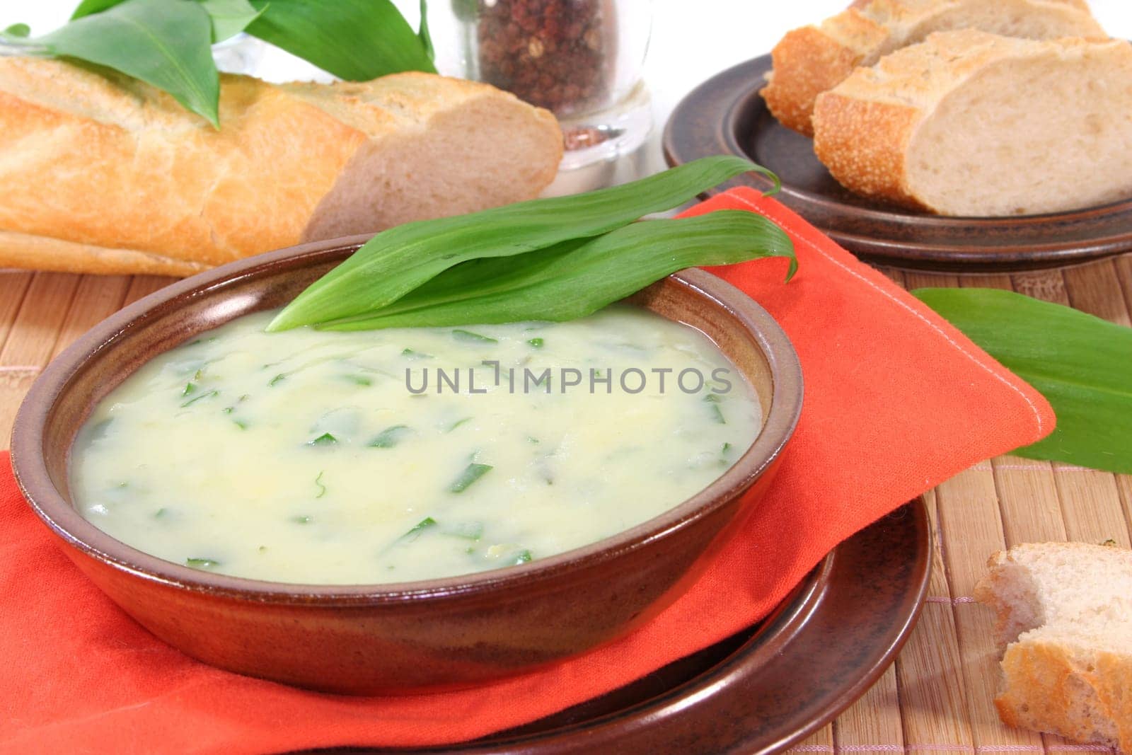 a bowl of wild garlic soup with fresh wild garlic