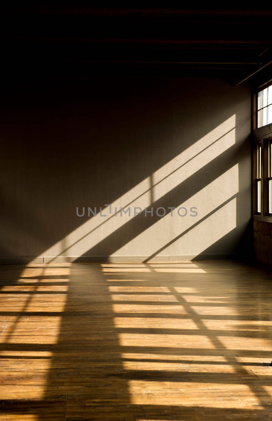 Image of a vacant loft with late evening light streaming thru windows onto hardwood floors.