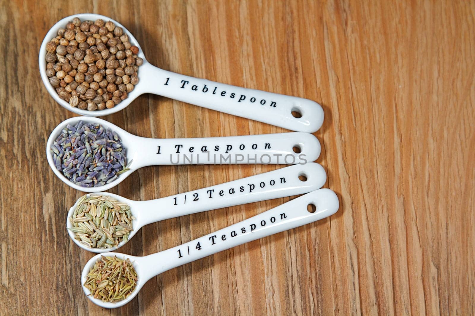 Old table-top selection of herbs and grains in measuring spoons