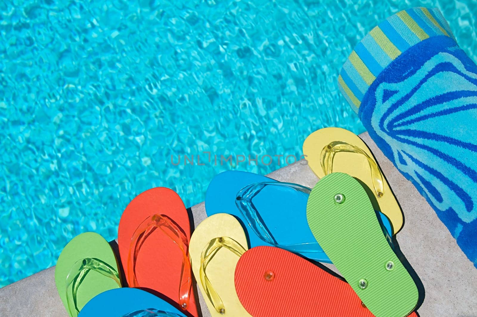 Colored flipflops of a family of four by the swimming pool