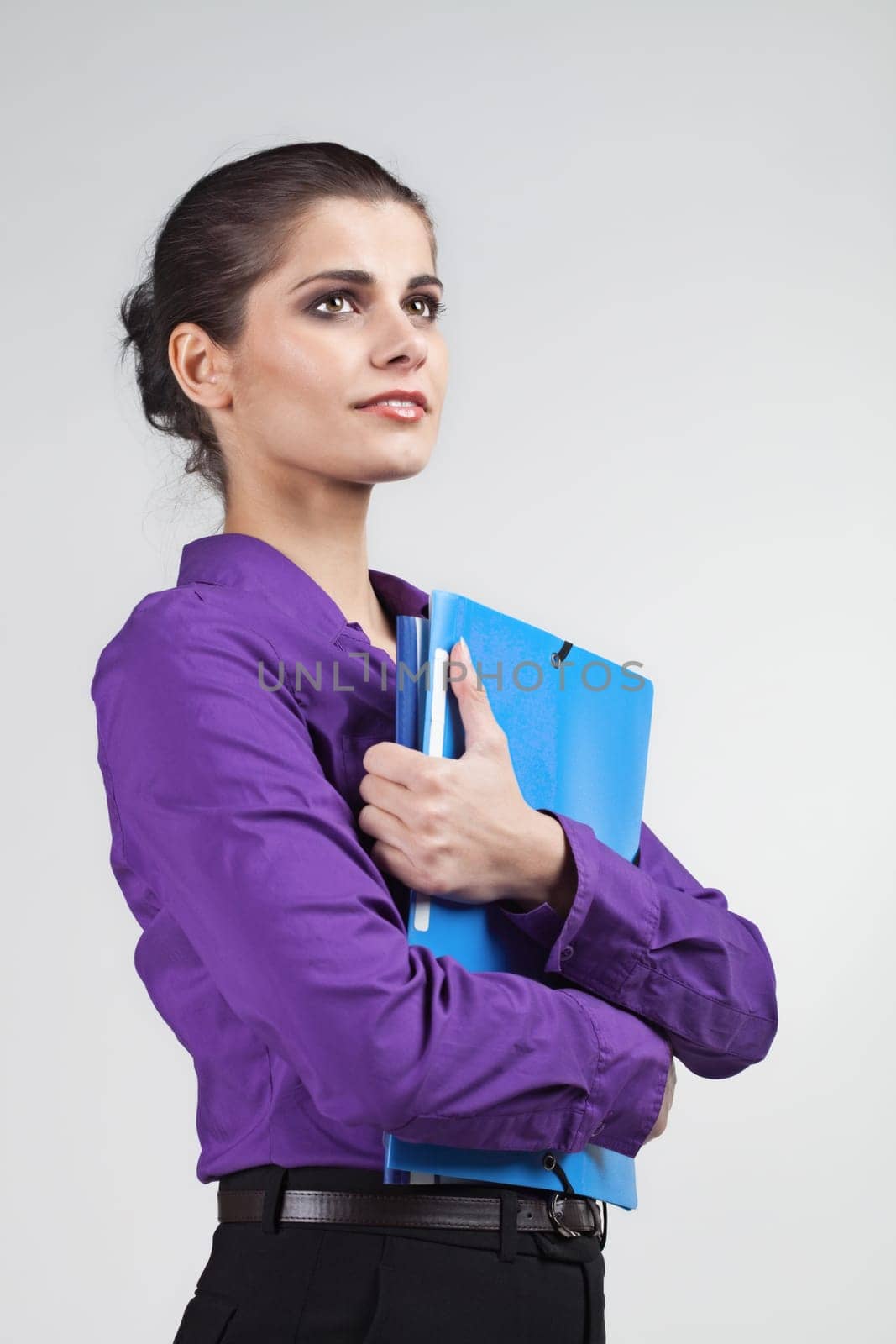 Pretty young brunette woman holding colorful plastic folders