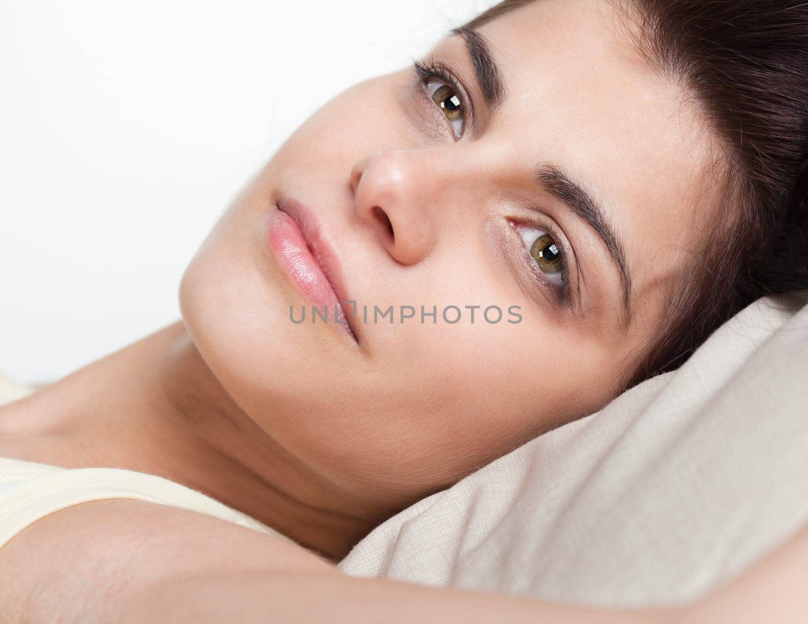 Closeup portrait of pretty young woman in bed