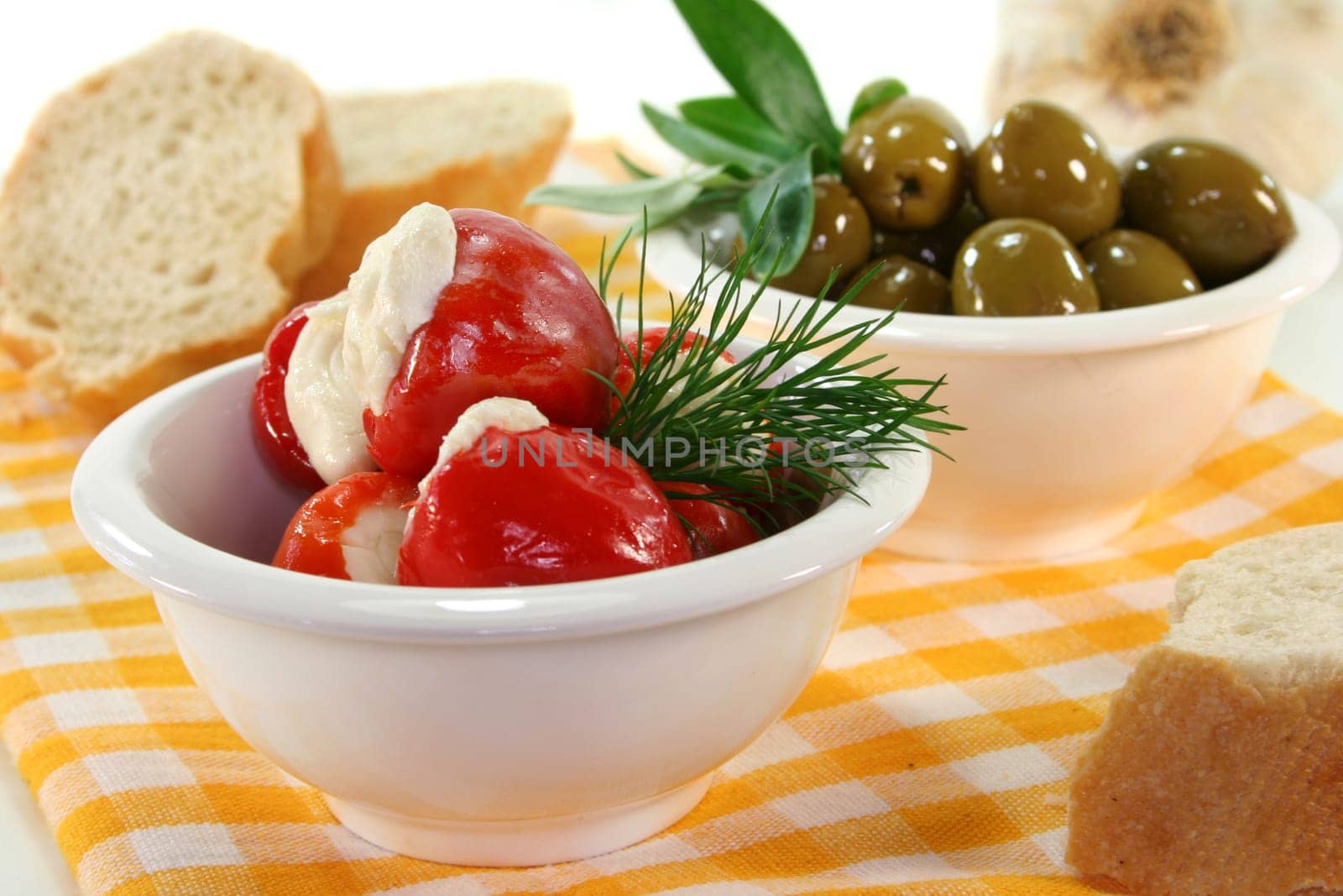 stuffed pepperoni and green olives in white bowls