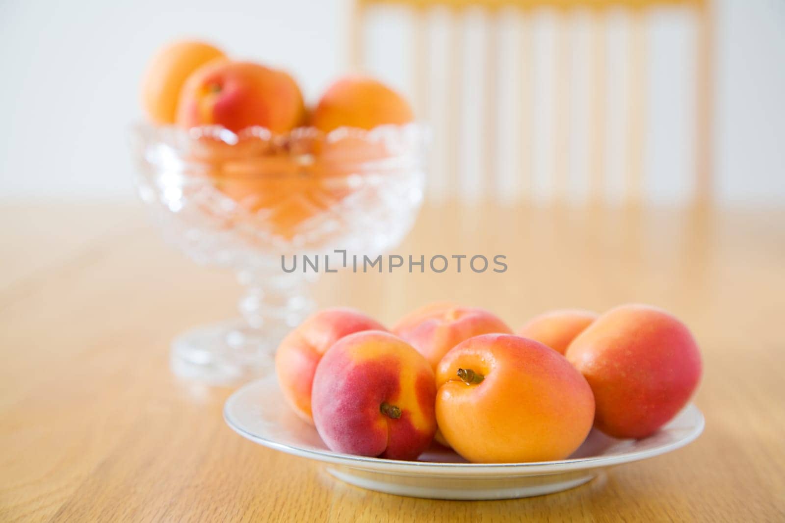 Image of fresh ripe apricots on a plate on dining table