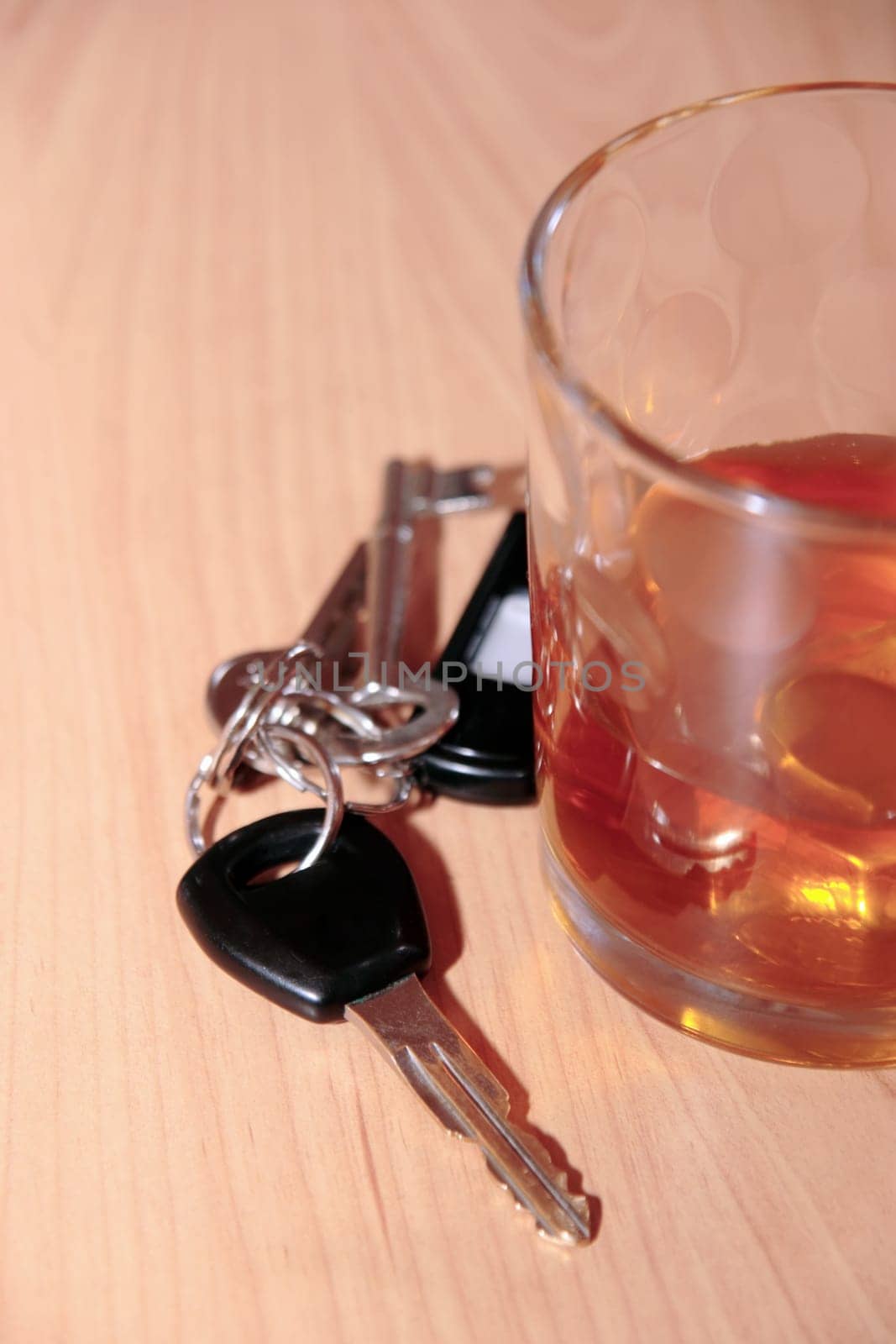 whiskey glass and keys on office desk depicting drinking and driving at work