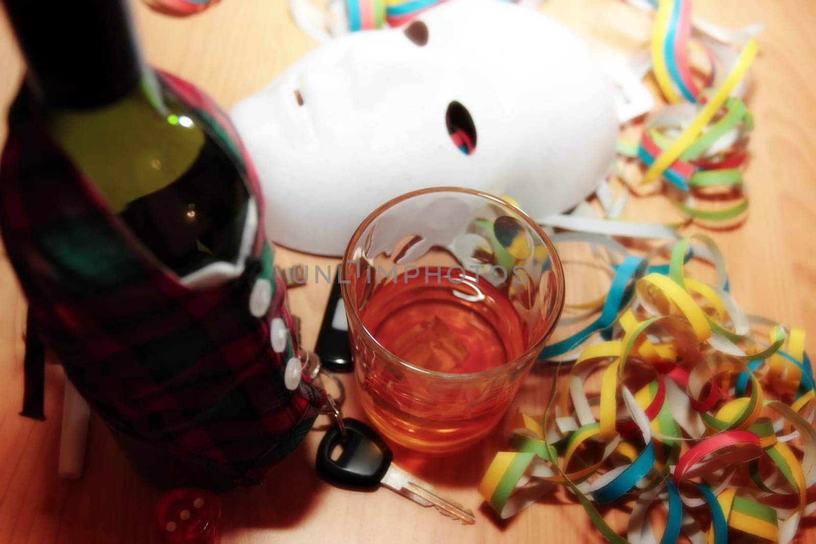 bottle dressed in jacket warmer with car keys on office desk at party depicting drunk driving and addictions can kill