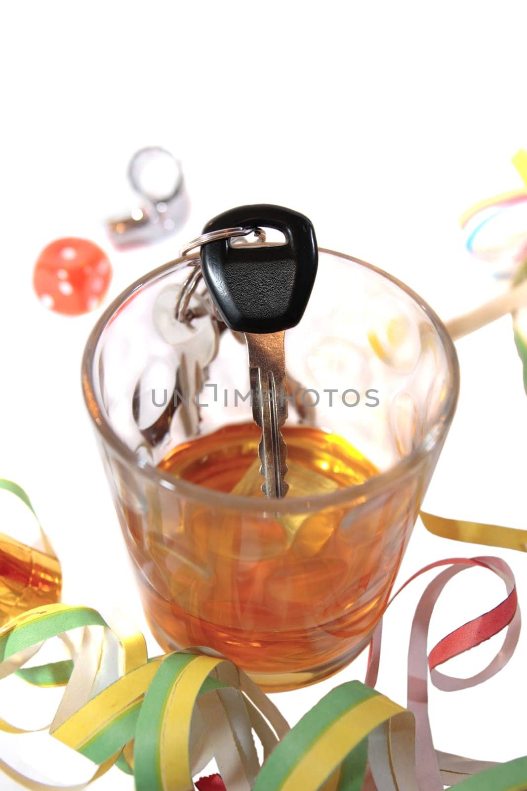whiskey glass with car keys on white background depicting drunk driving and addictions can kill