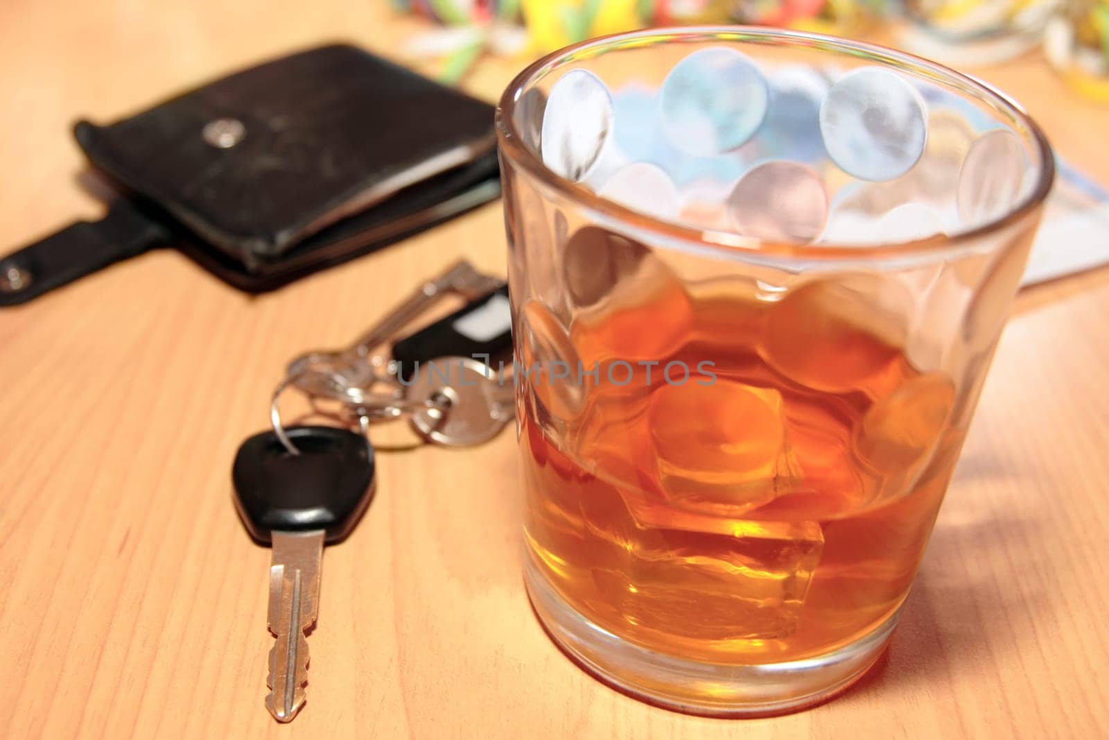 wallet whiskey glass and keys at office party on desk depicting dont drink and drive