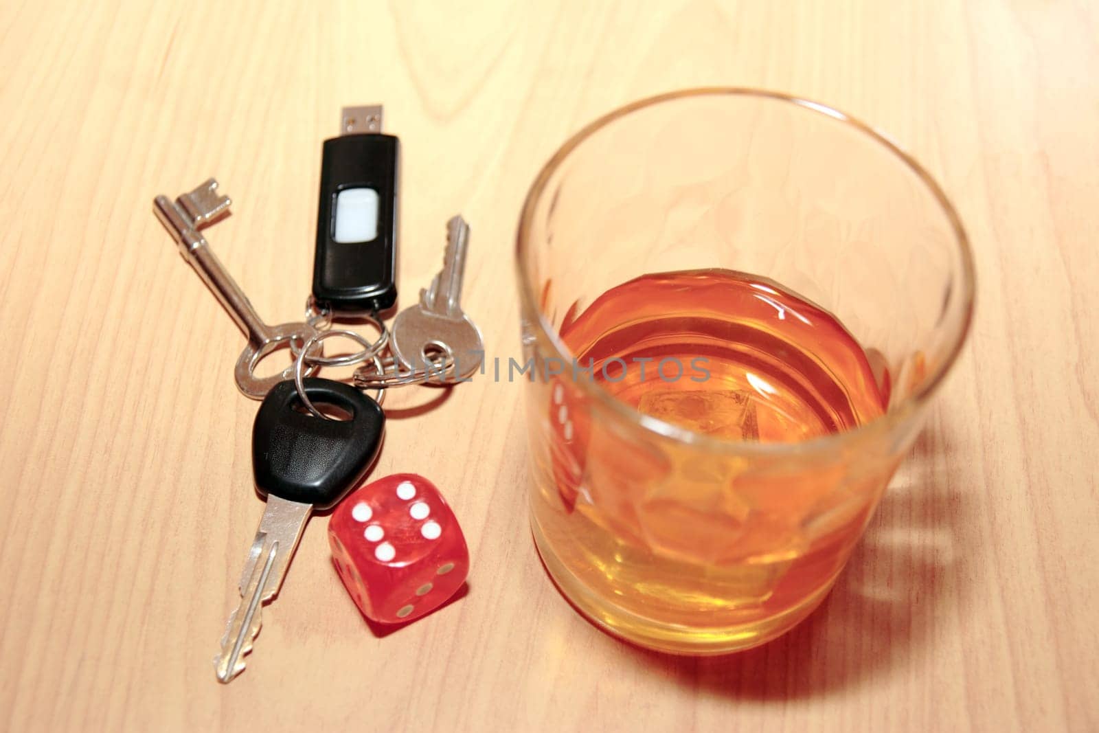 whiskey glass and keys and dice on office desk depicting dont gamble with your life