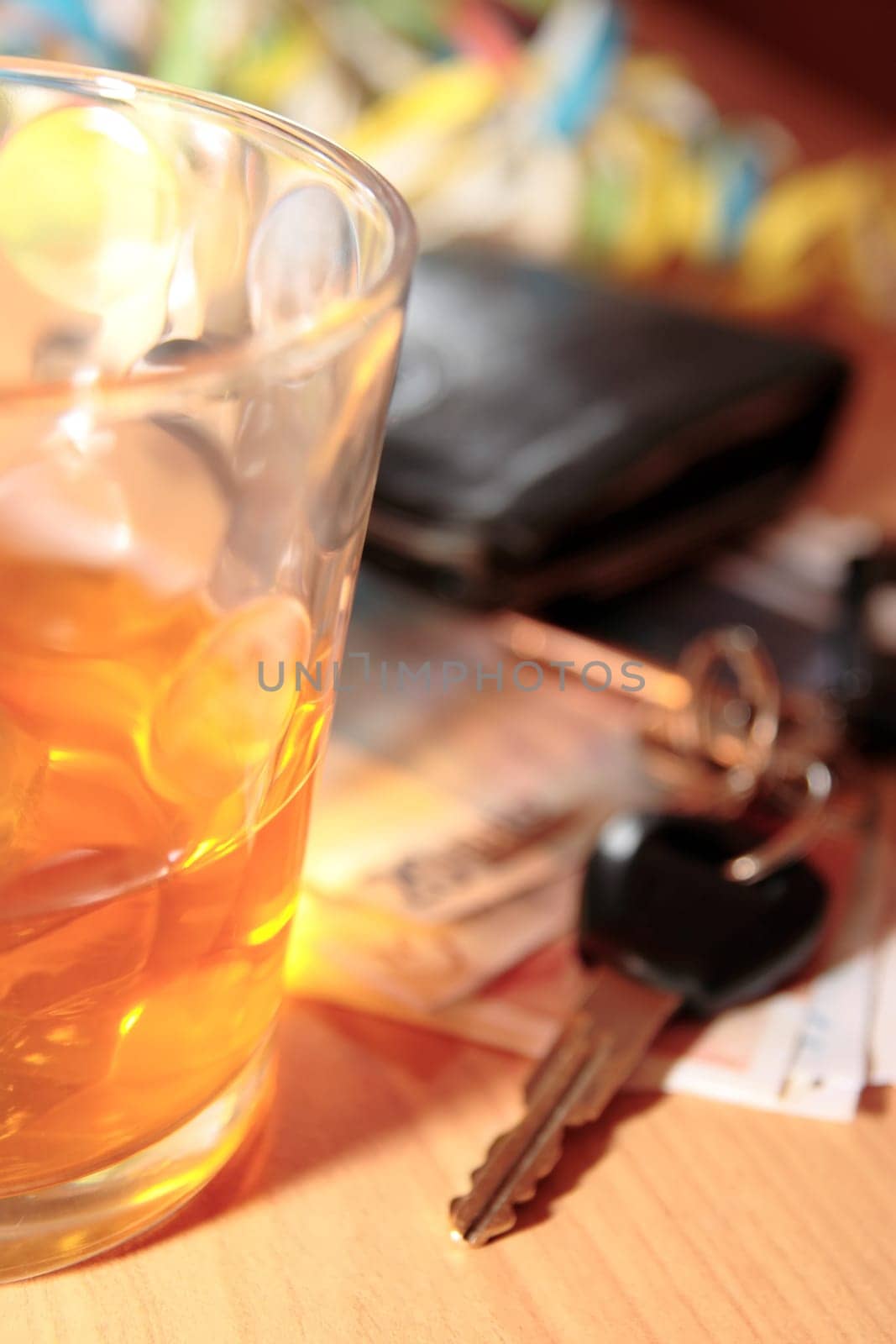 wallet whiskey glass and keys at office party on desk depicting dont drink and drive