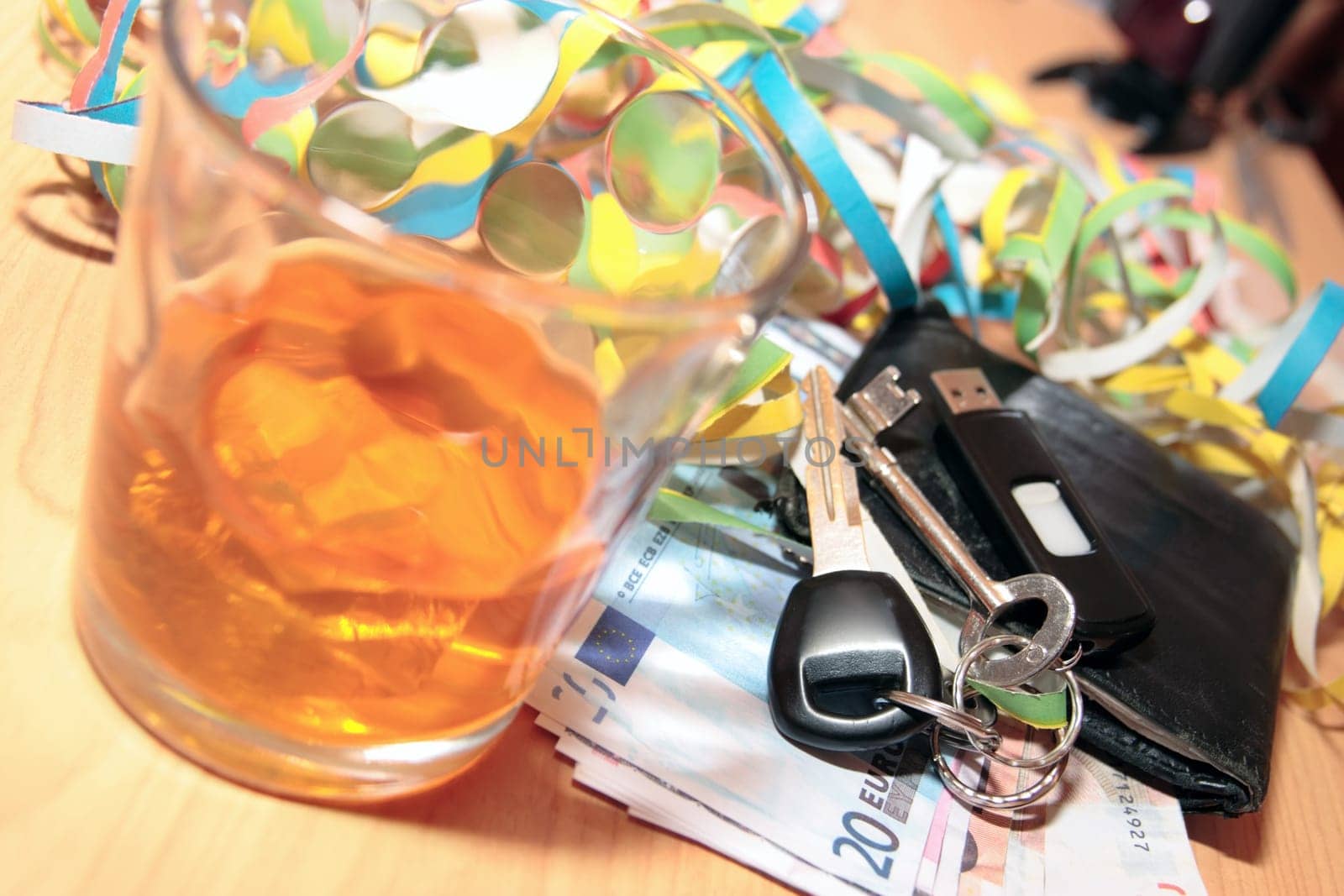 wallet whiskey glass and keys at office party on desk depicting dont drink and drive