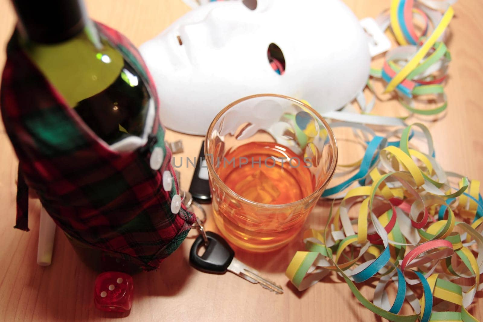 bottle dressed in jacket warmer with car keys on office desk at party depicting drunk driving and addictions can kill