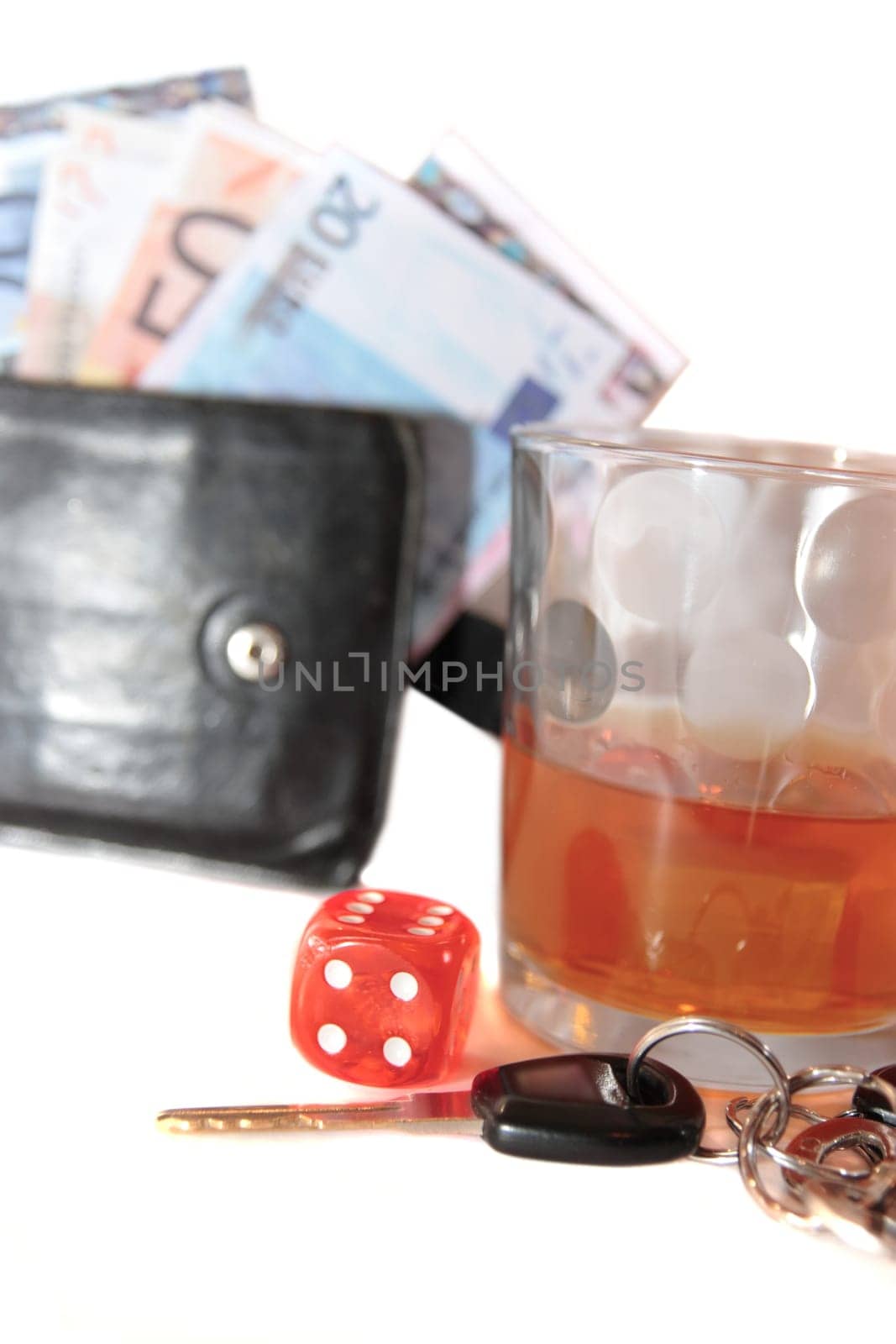 dice and whiskey glass with car keys and cash on white background depicting gambling with drunk driving and addictions can kill