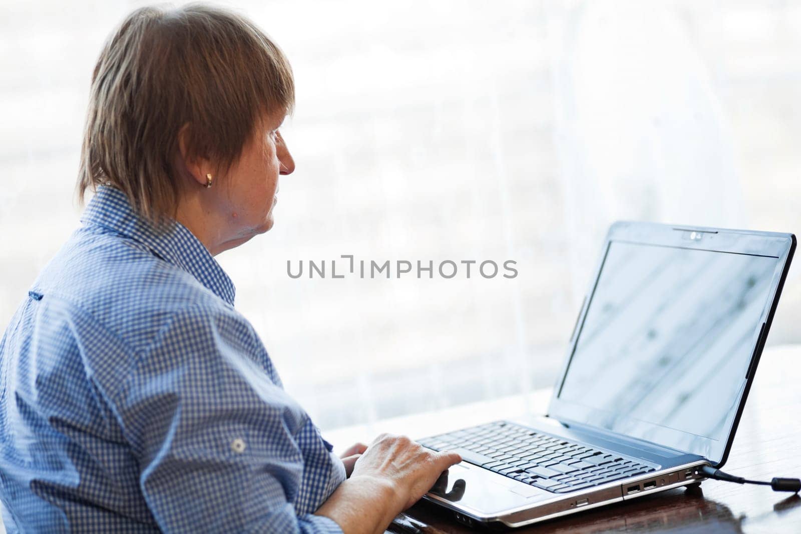 Elder woman working with laptop computer at home