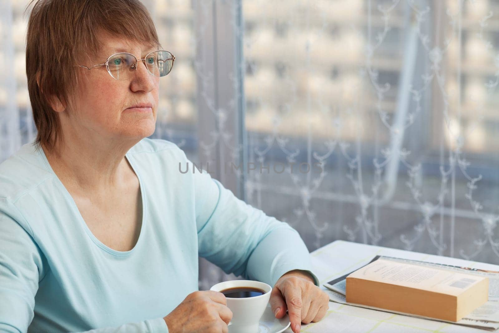 Elderly woman enjoying a cup of coffee at home