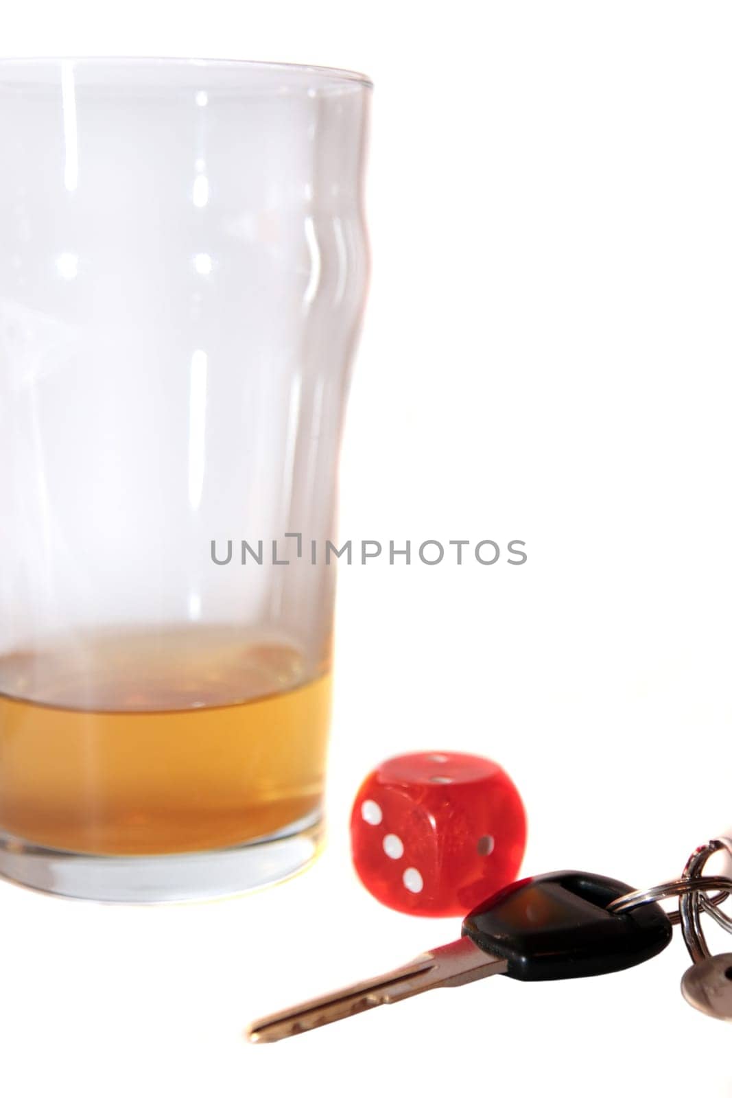 dice and beer glass with car keys on white background depicting gambling with drunk driving and addictions can kill
