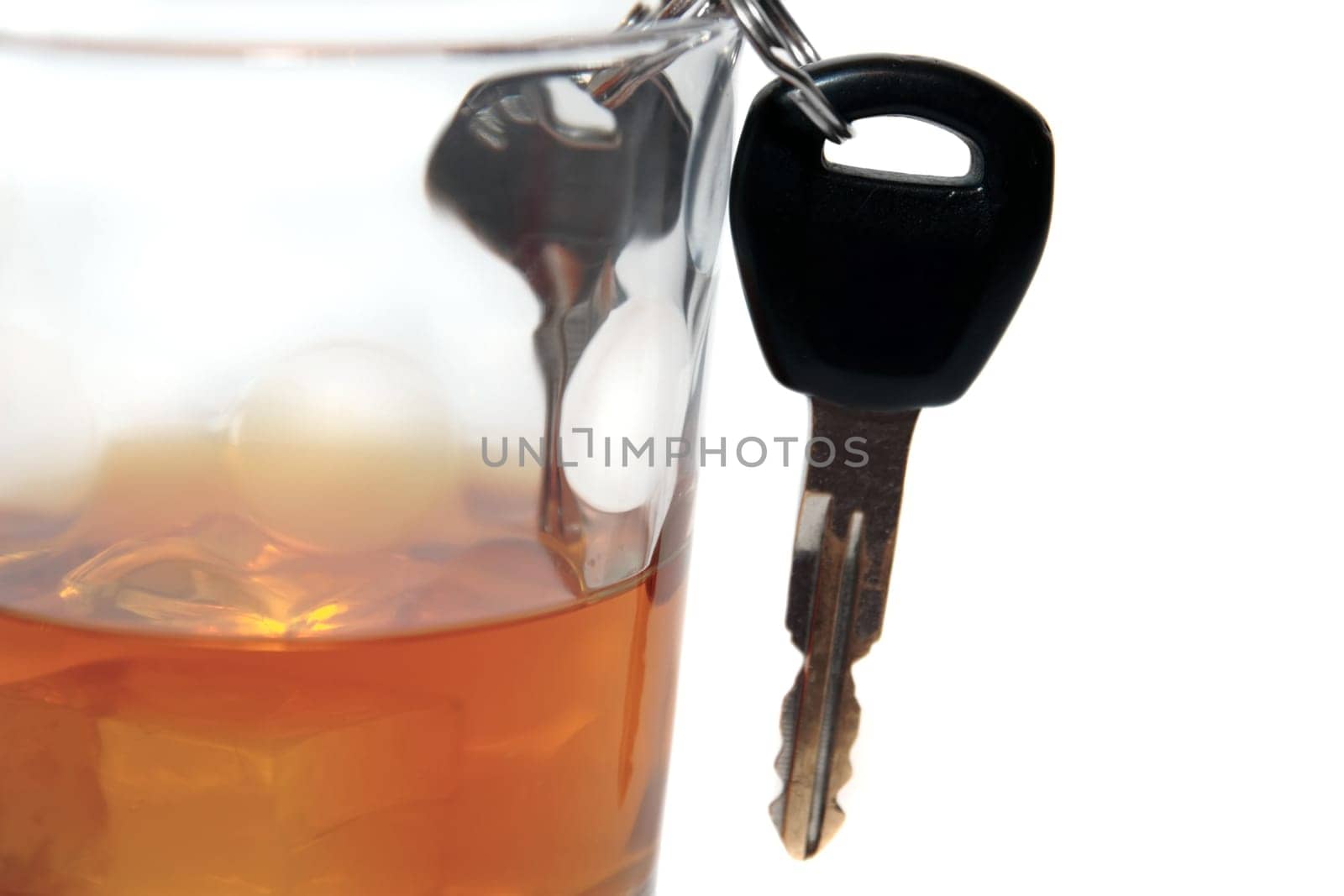 bourbon with keys inside glass on white background depicting drunk driving and addictions can kill