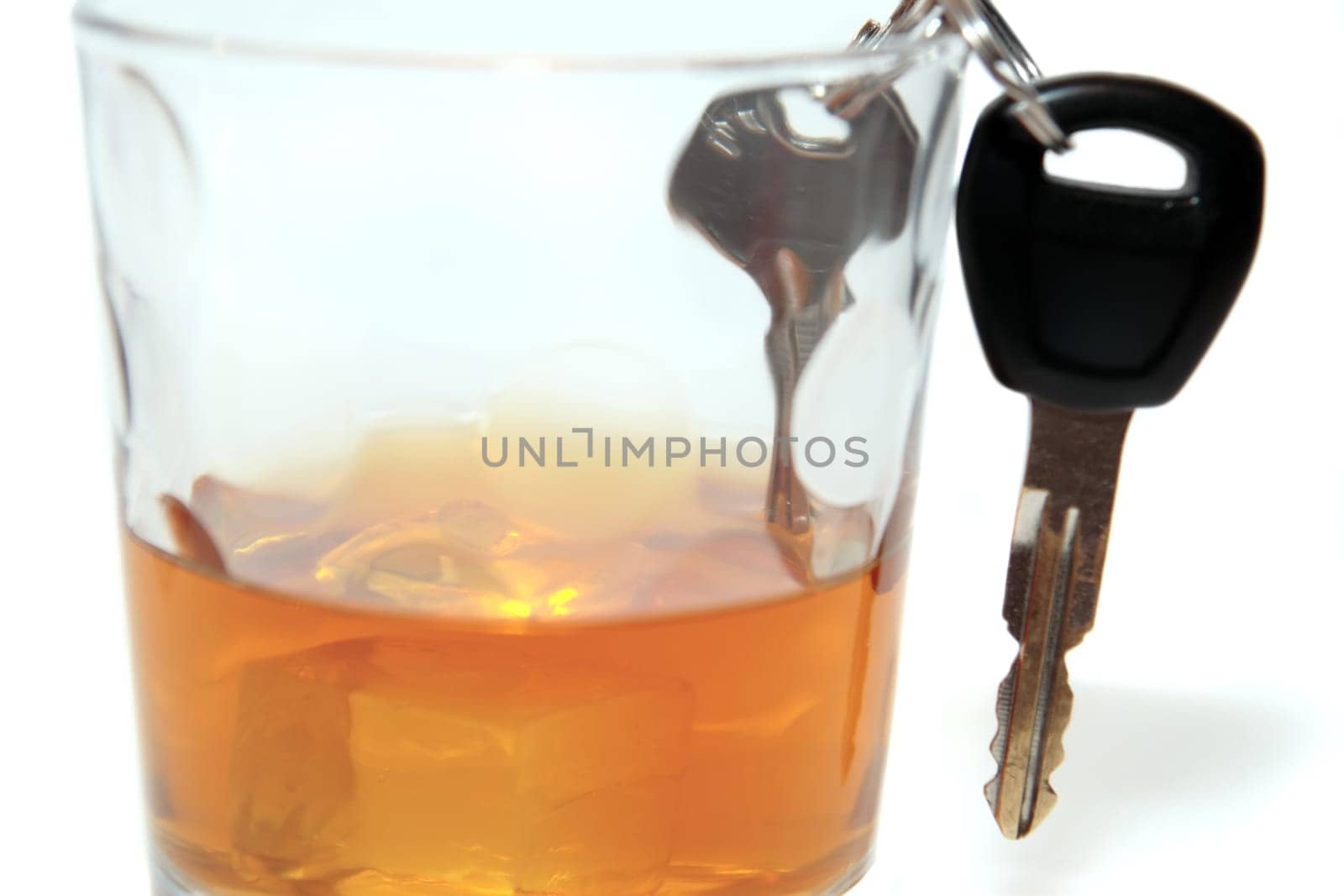 bourbon with keys inside glass on white background depicting drunk driving and addictions can kill