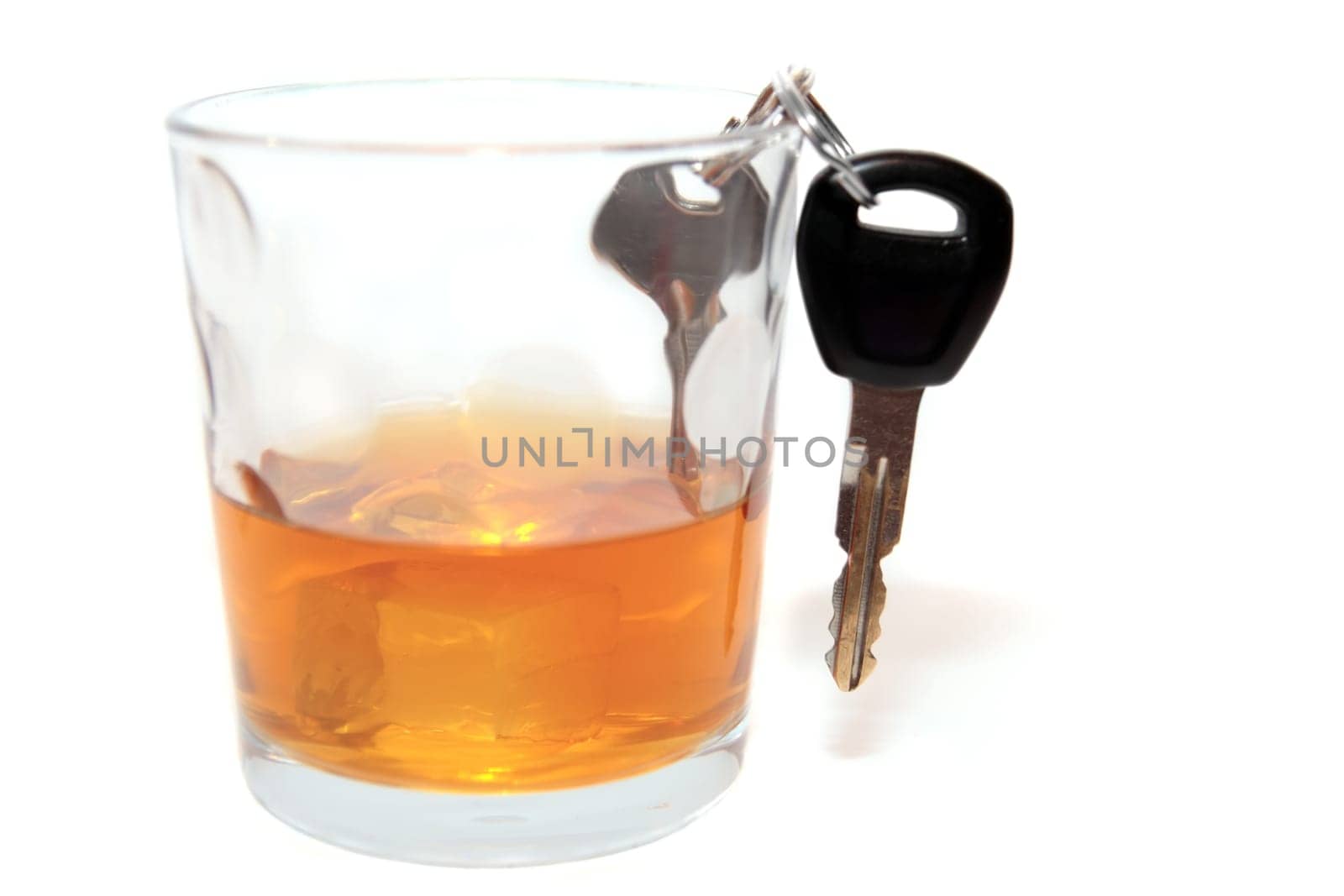 bourbon with keys inside glass on white background depicting drunk driving and addictions can kill