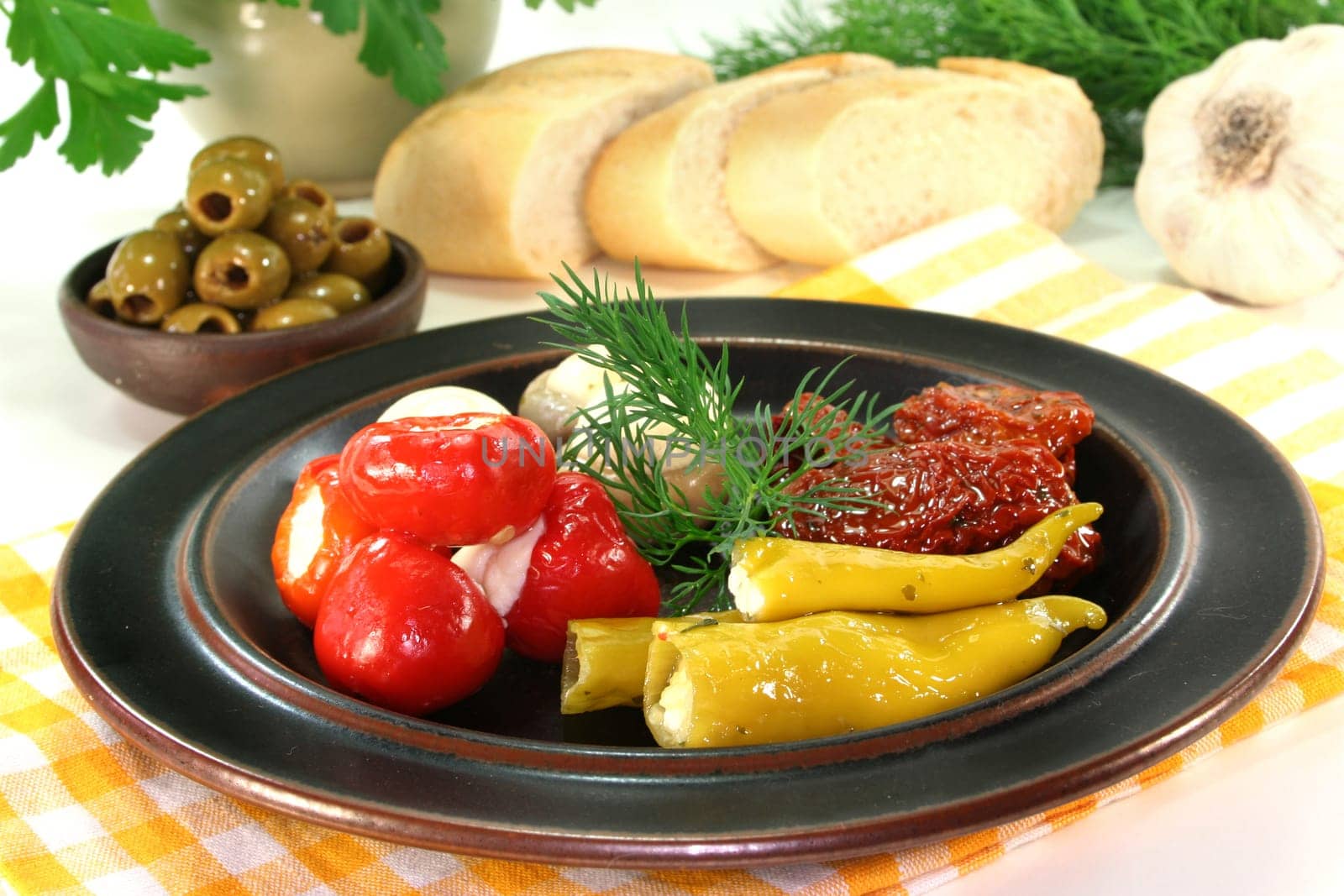 stuffed pepperoni,tomatoes and green olives against a white background