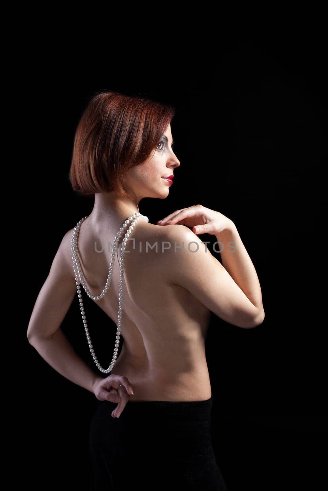 Woman with naked spine and pearl beads - retro style make-up
