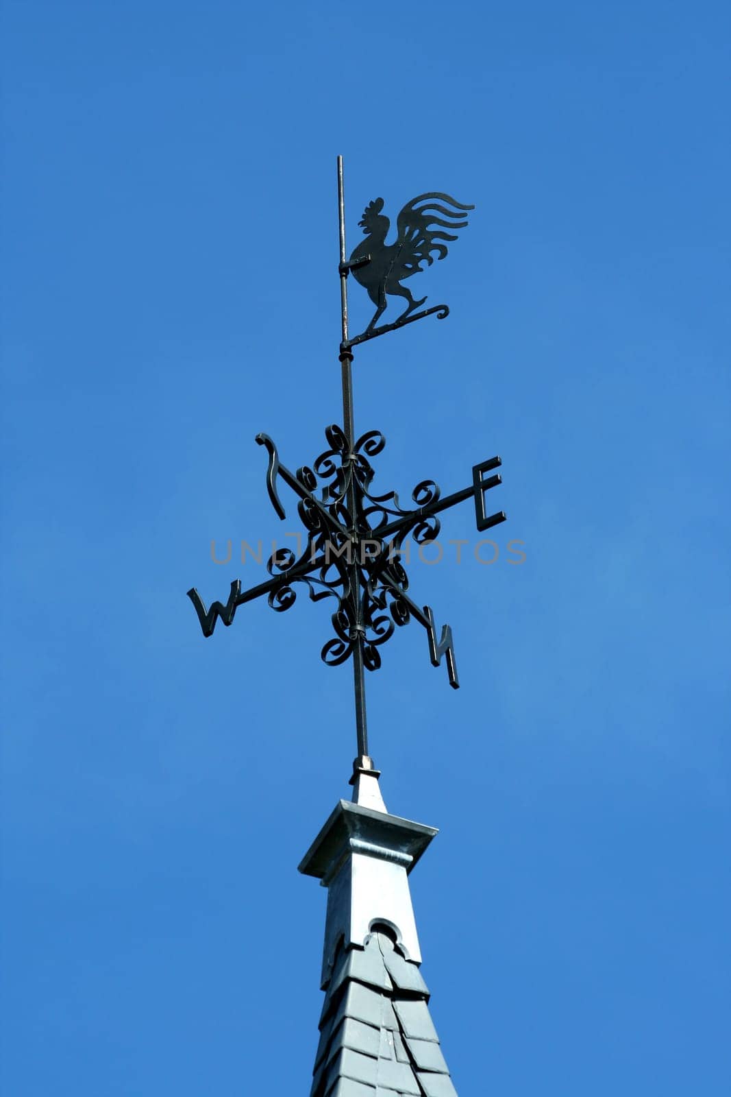 Rooster weather vane against blue sky