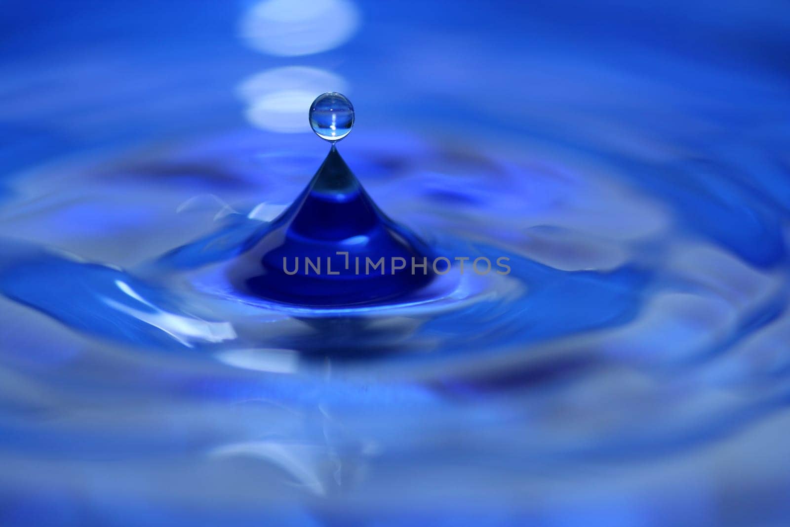 A blue water droplet splashing