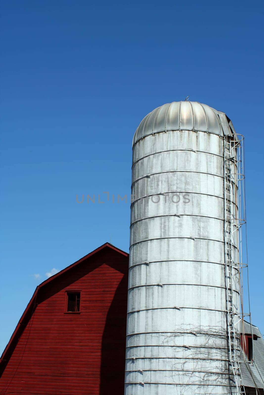 A Red barn and silo against blue sky