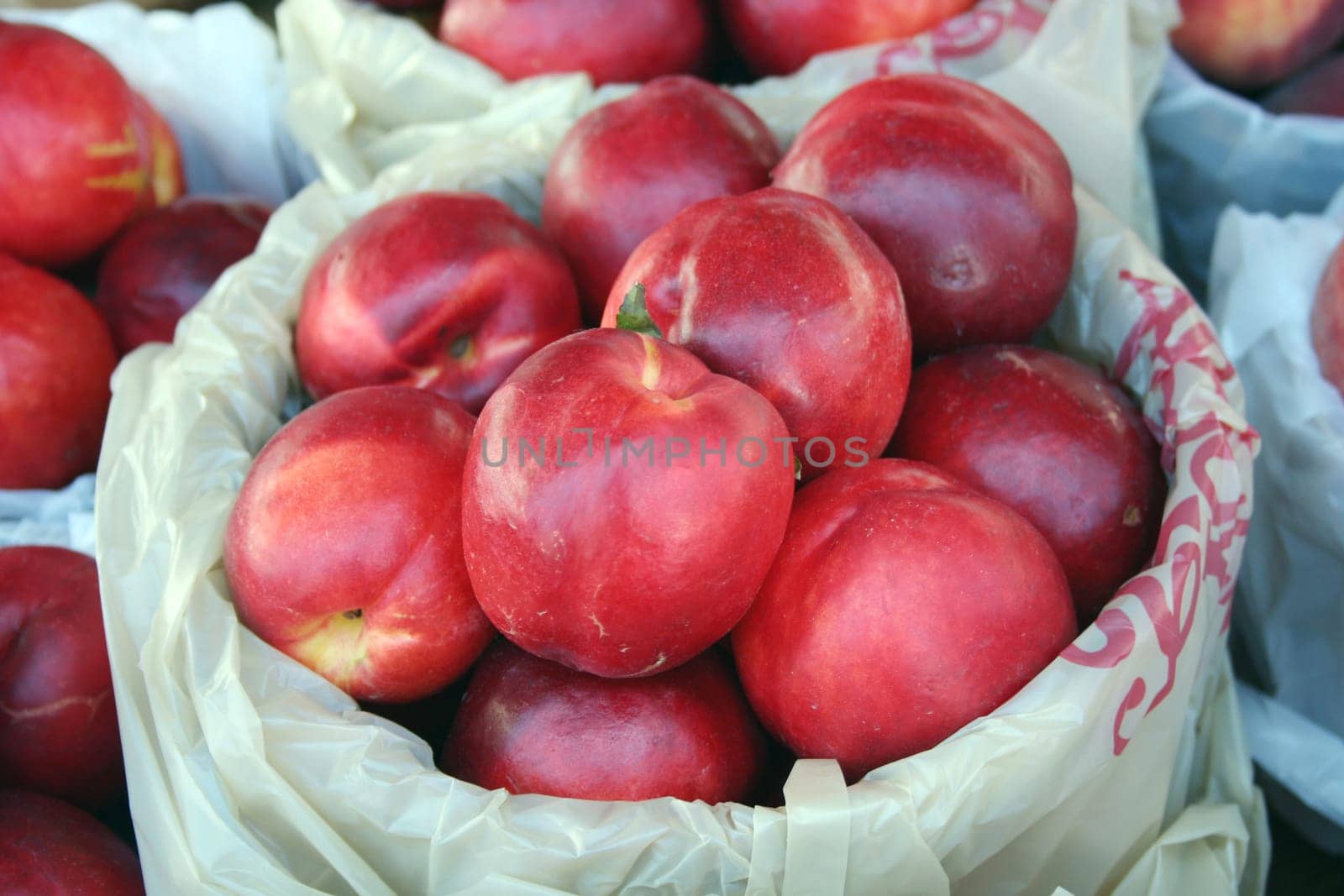 a backet of nectarines for sale at the market