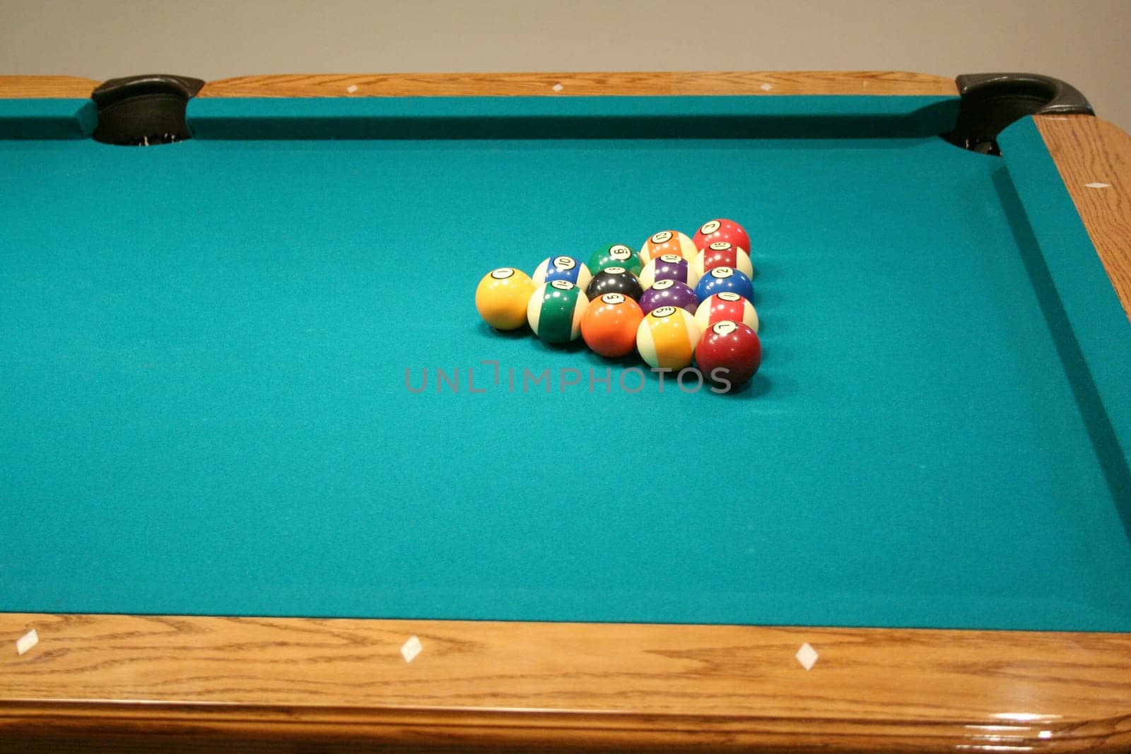 Racked 8 ball game on a green pool table