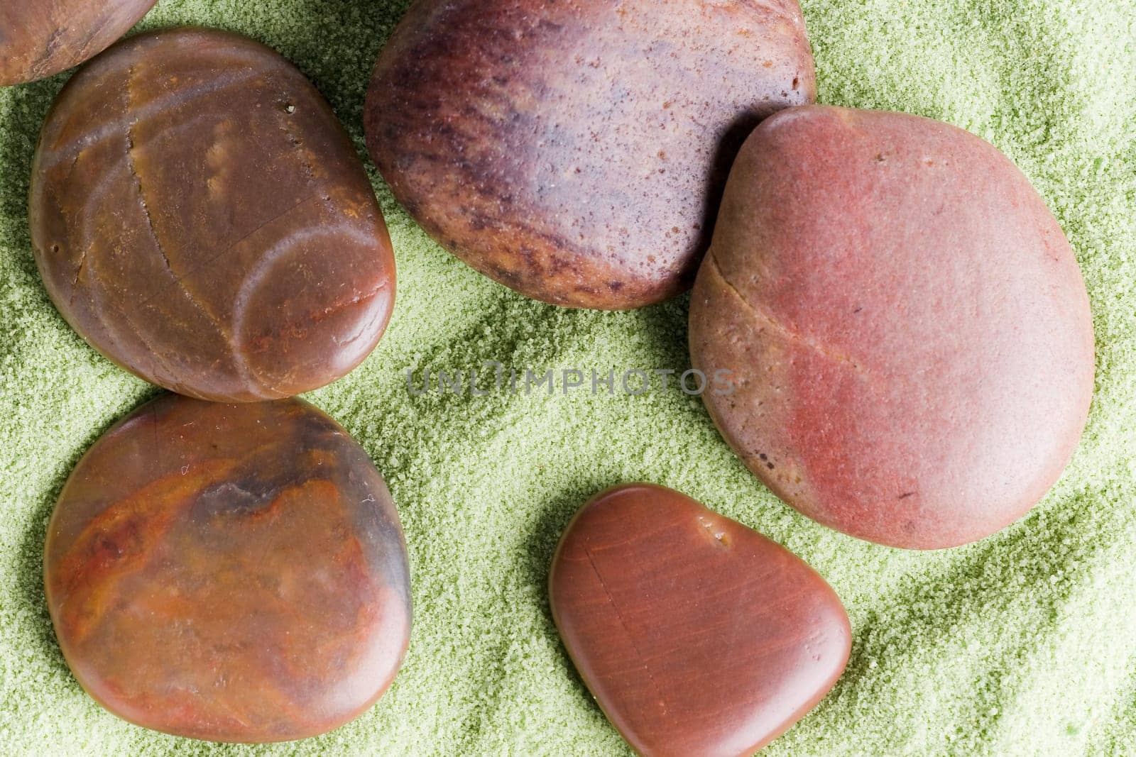 Brown stones messed up on green sand