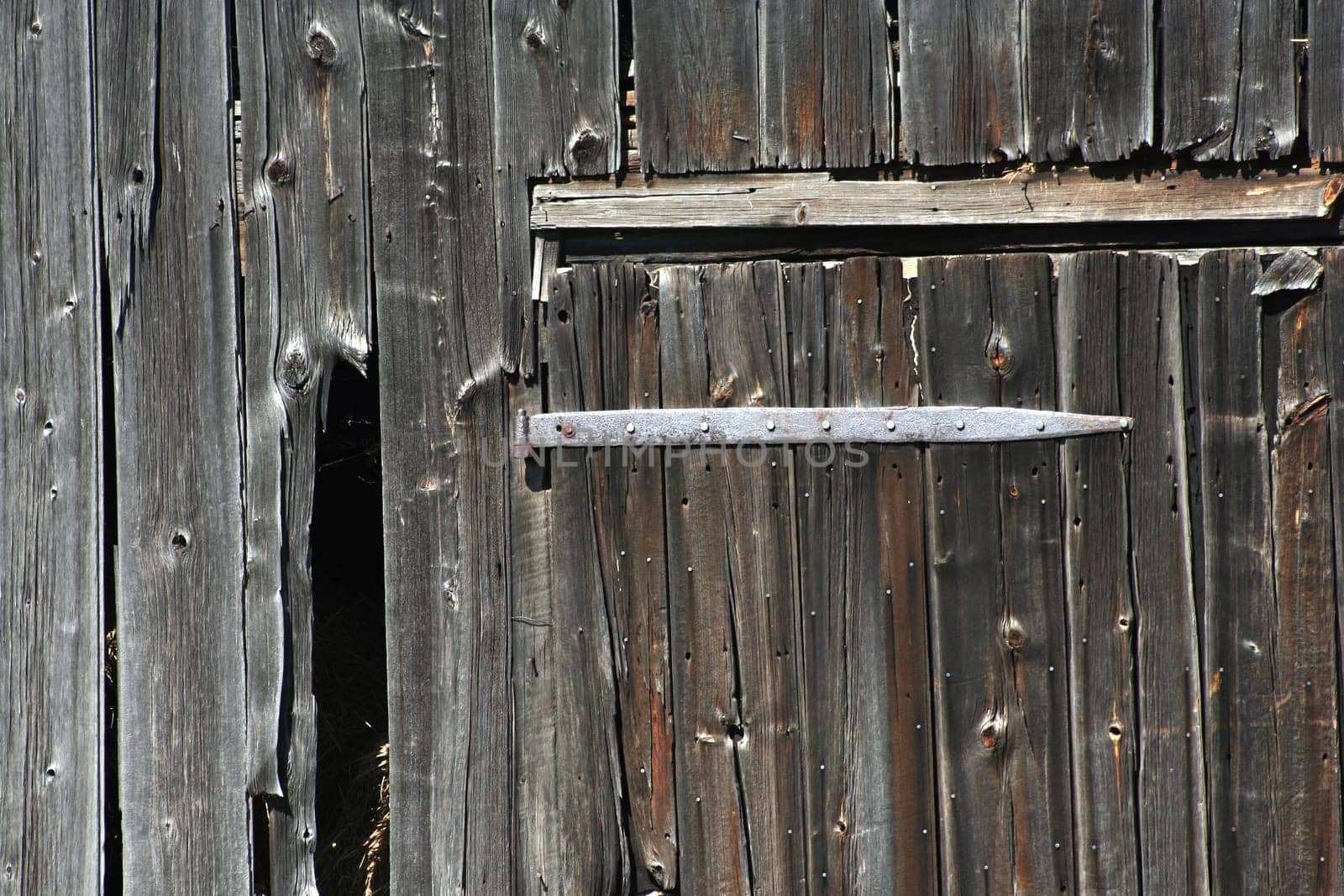 An Old wooden barn door and hinge