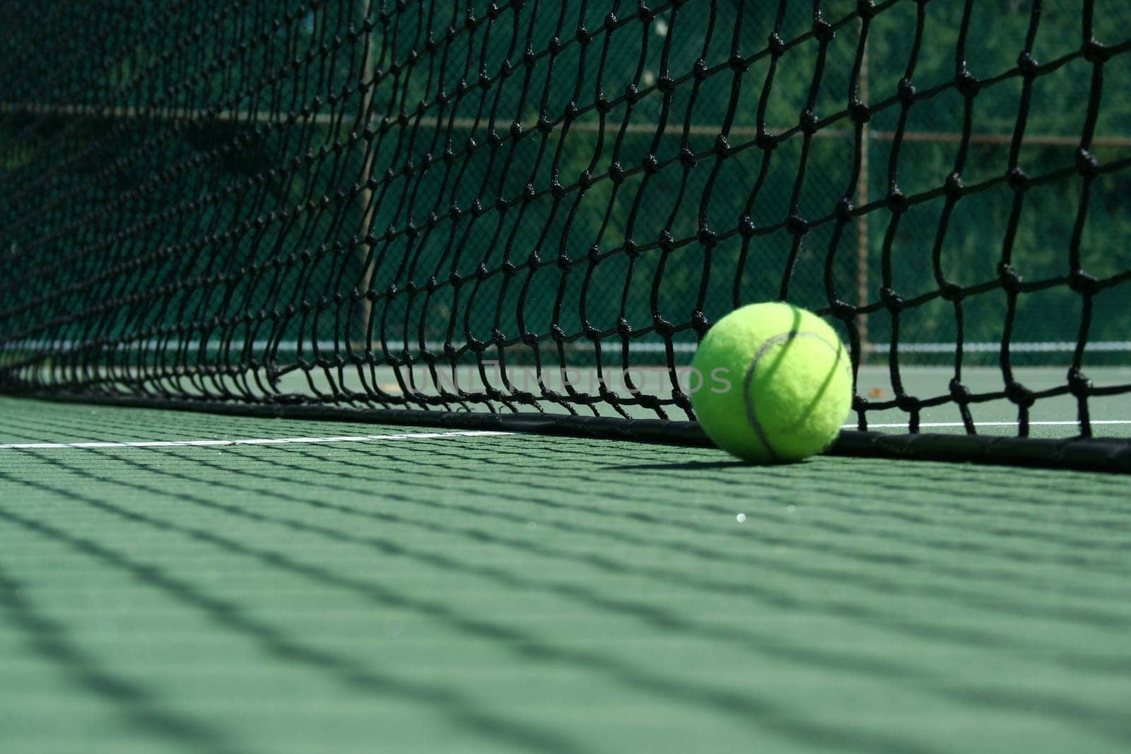 A Tennis ball near net with showdows