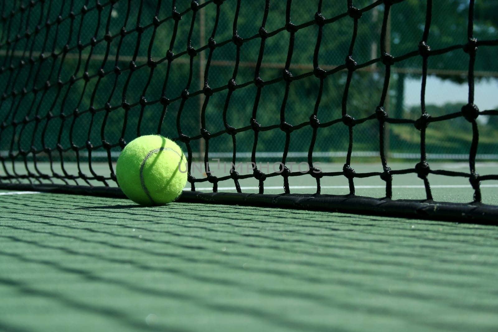 A Tennis ball near net with showdows