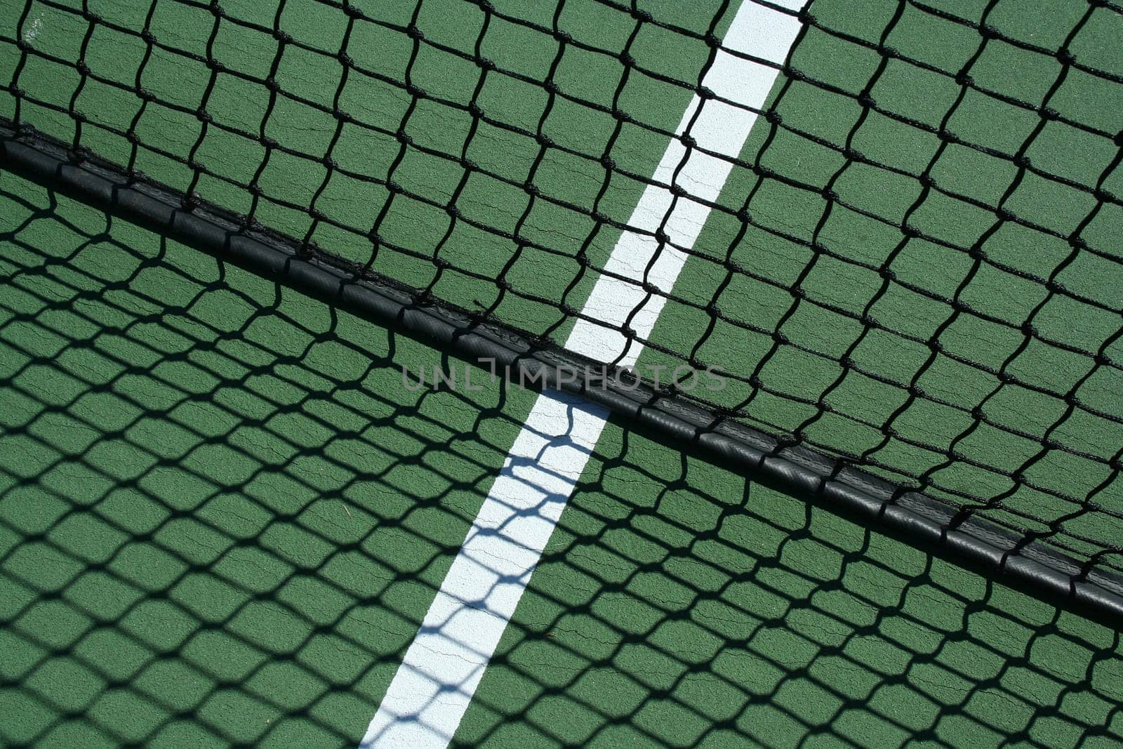 A Tennis net and shadows with white line