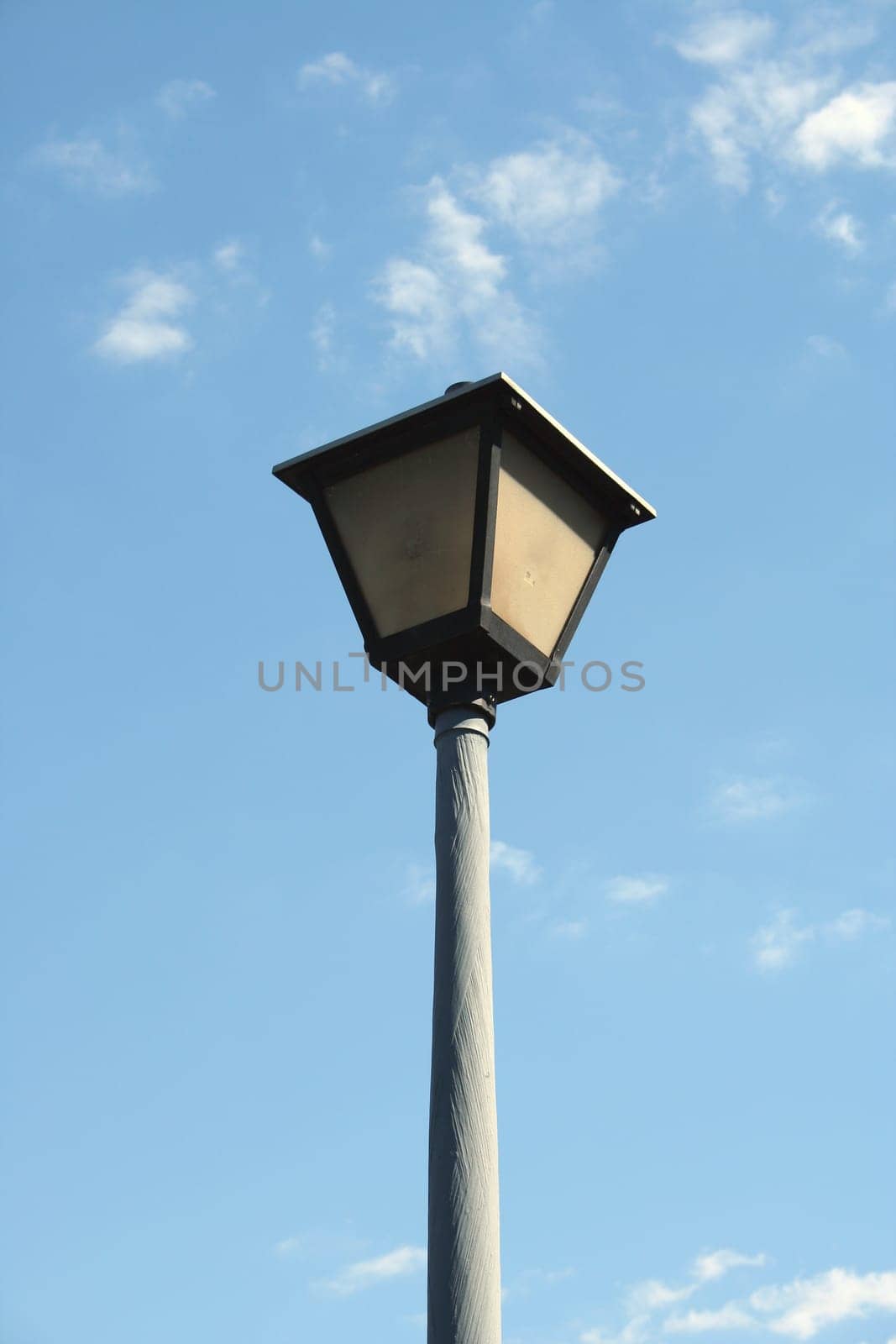 Lamppost against a blue cloudy sky