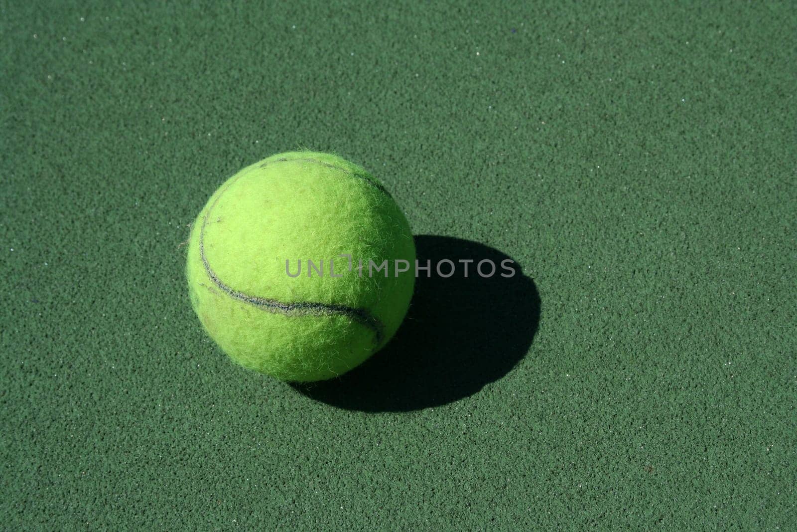 A Tennis ball on a green court