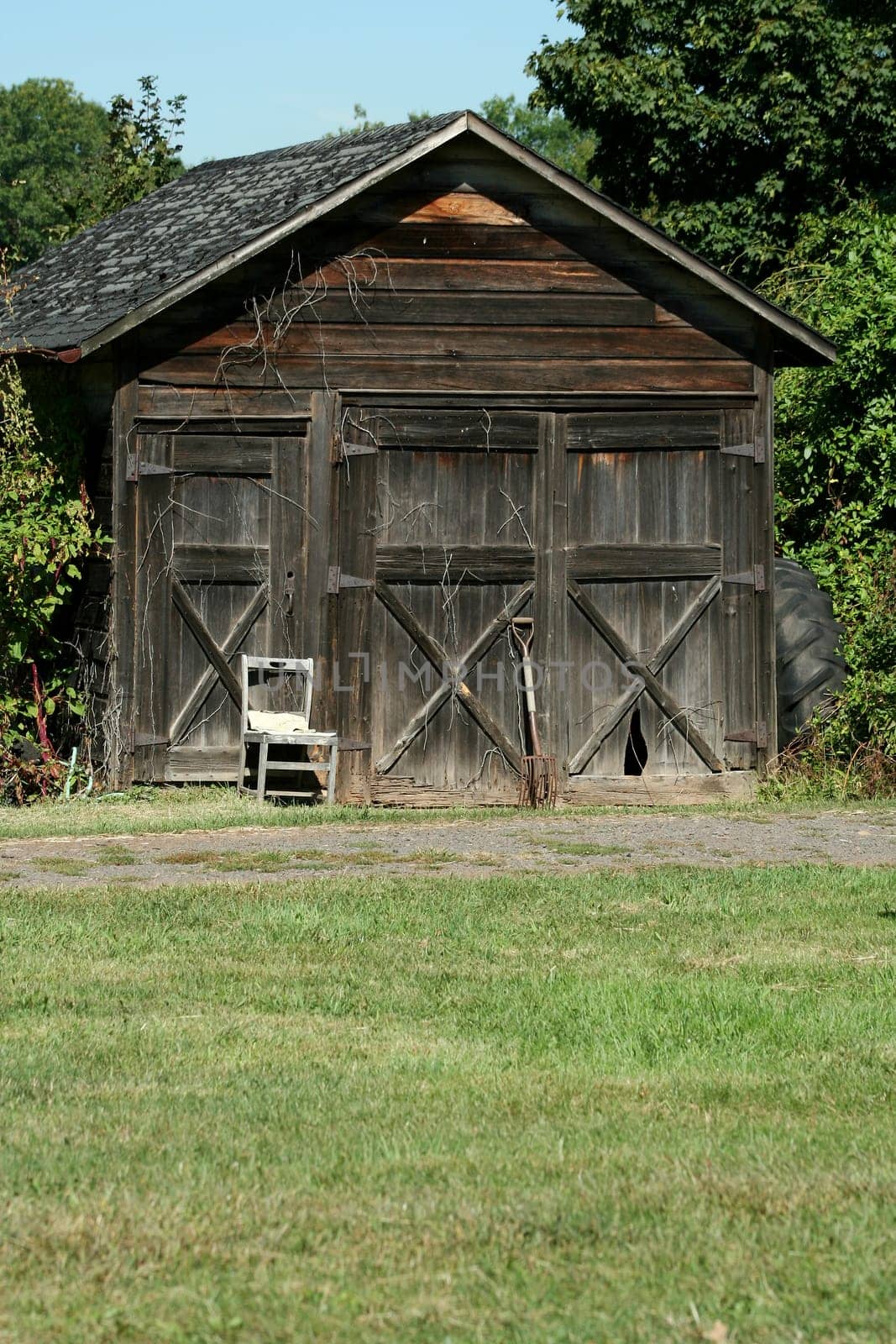 An Old wooden barn with grass and sky
