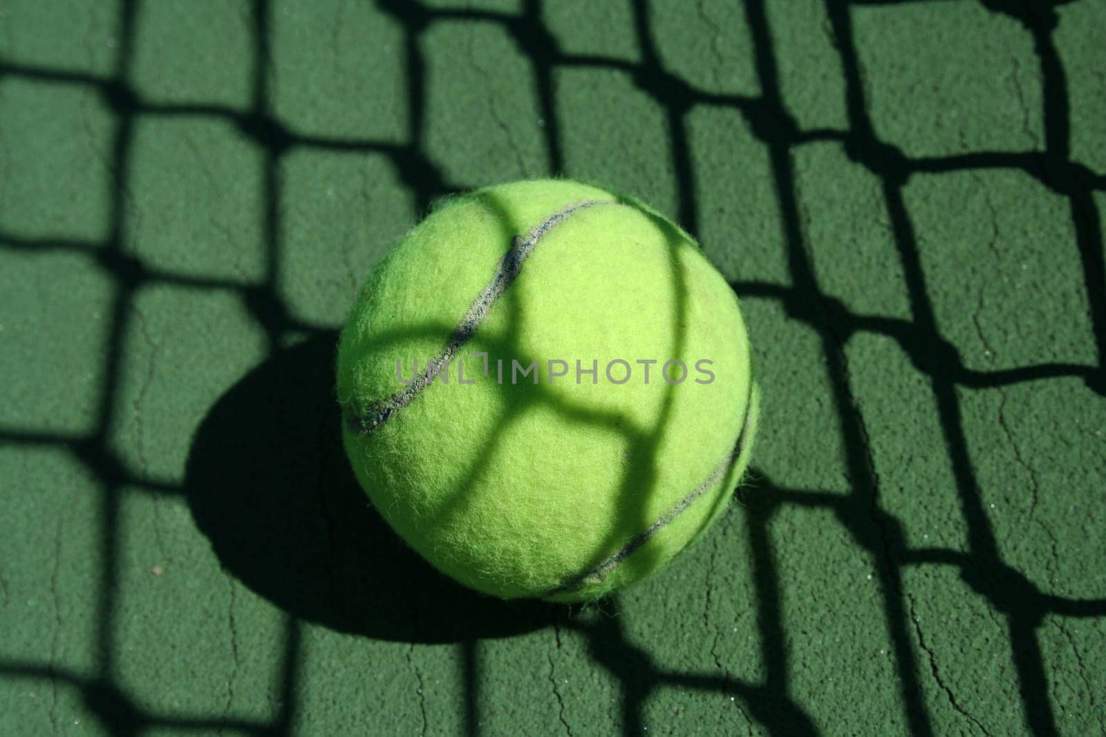 A Tennis ball near net with showdows