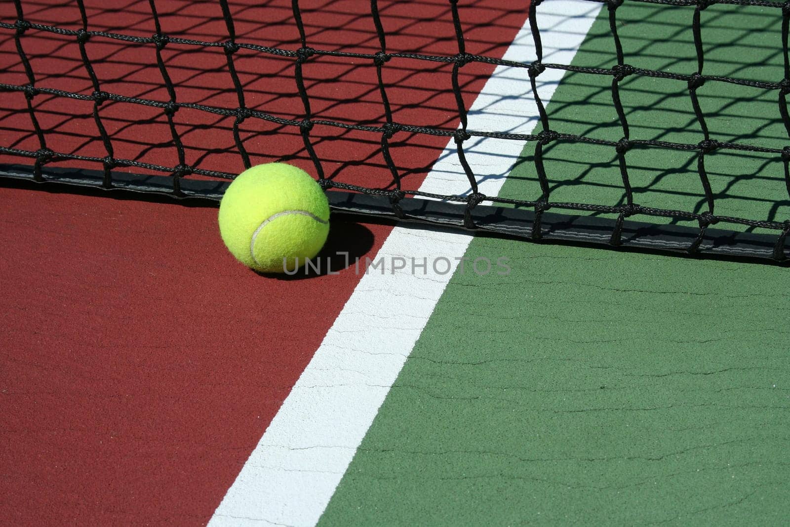 A Tennis Ball out of bounds with white line and net