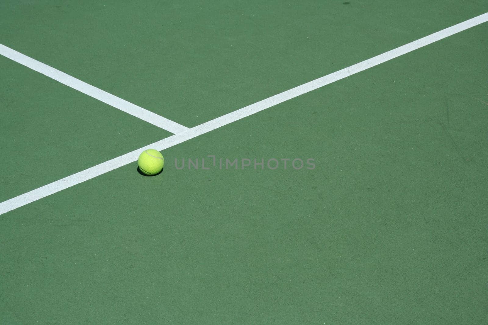 A Tennis ball on a green court