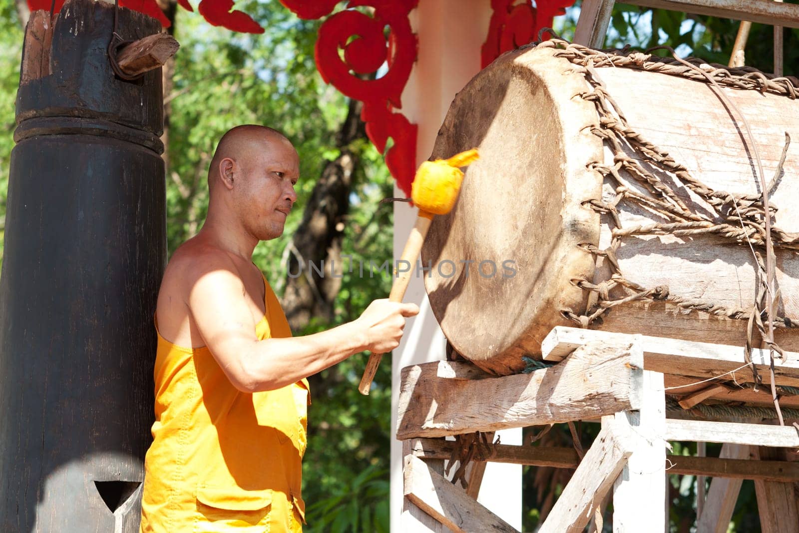Buddhist monk beating the drum in the temple complex