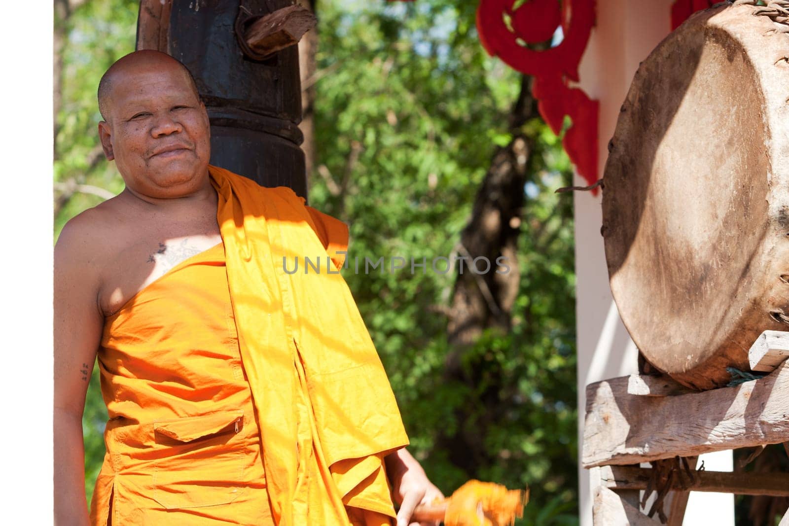 Buddhist monk beating the drum in the temple complex