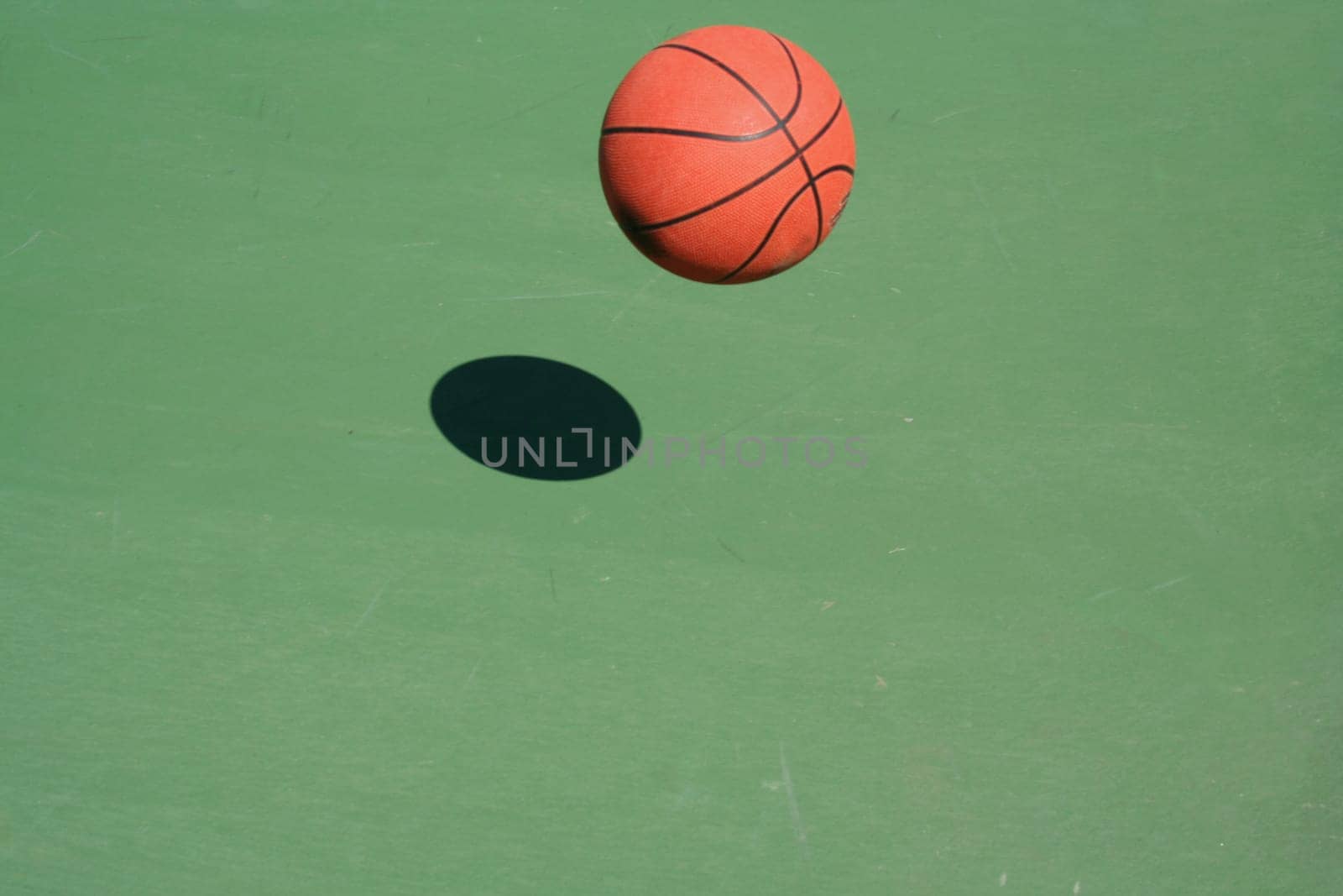 A bouncing Basketball green court with shadow