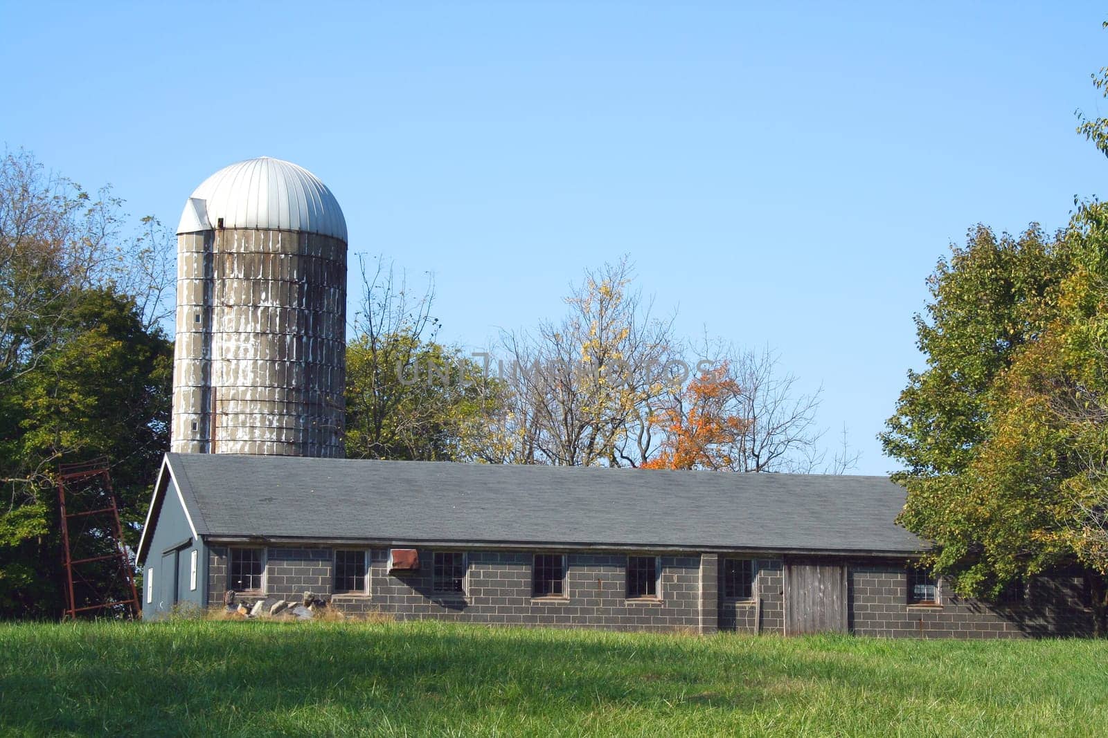 A Barn and silo against a blue sky