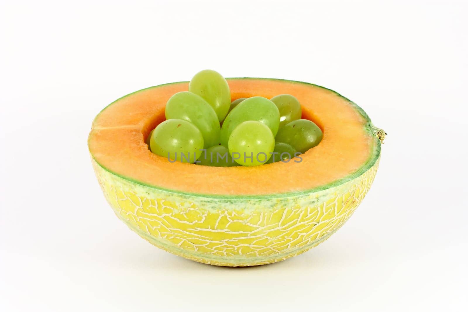 Grapes in a hole of melon isolated on white